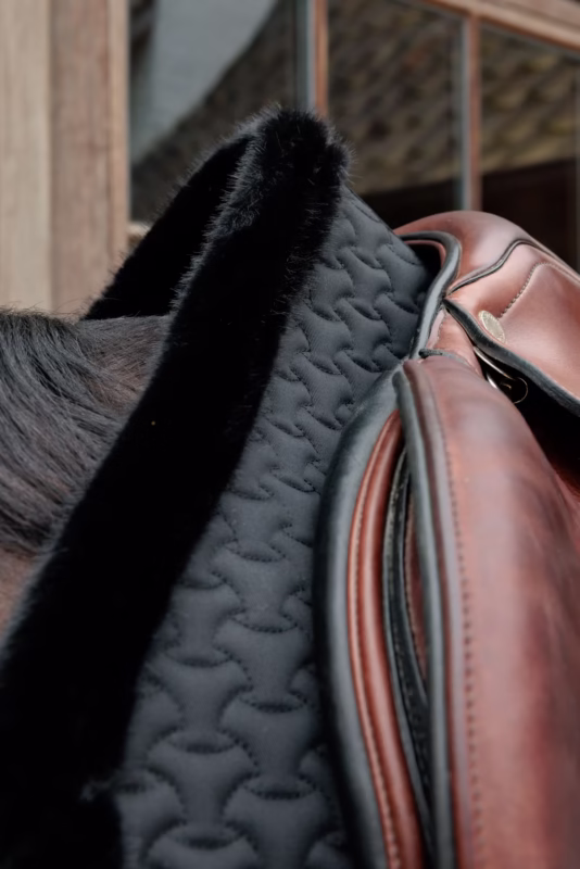 Różowy czaprak z czarną lamówką i futerkiem pod siodłem